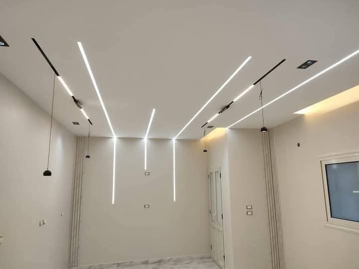 Plafond à éclairage LED linéaire oblique et pilastres en plâtre