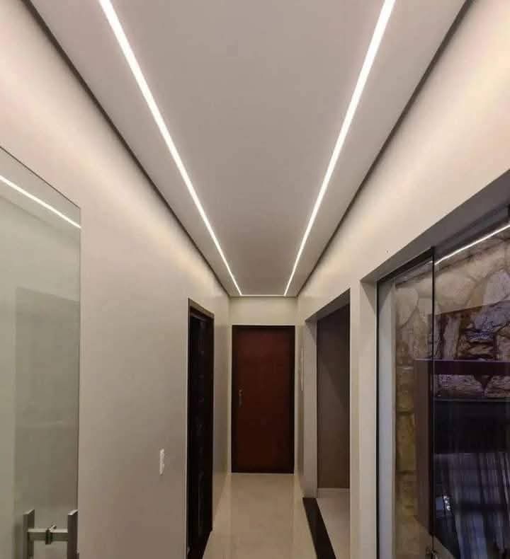 Couloir avec faux plafond en plâtre à lignes lumineuses LED