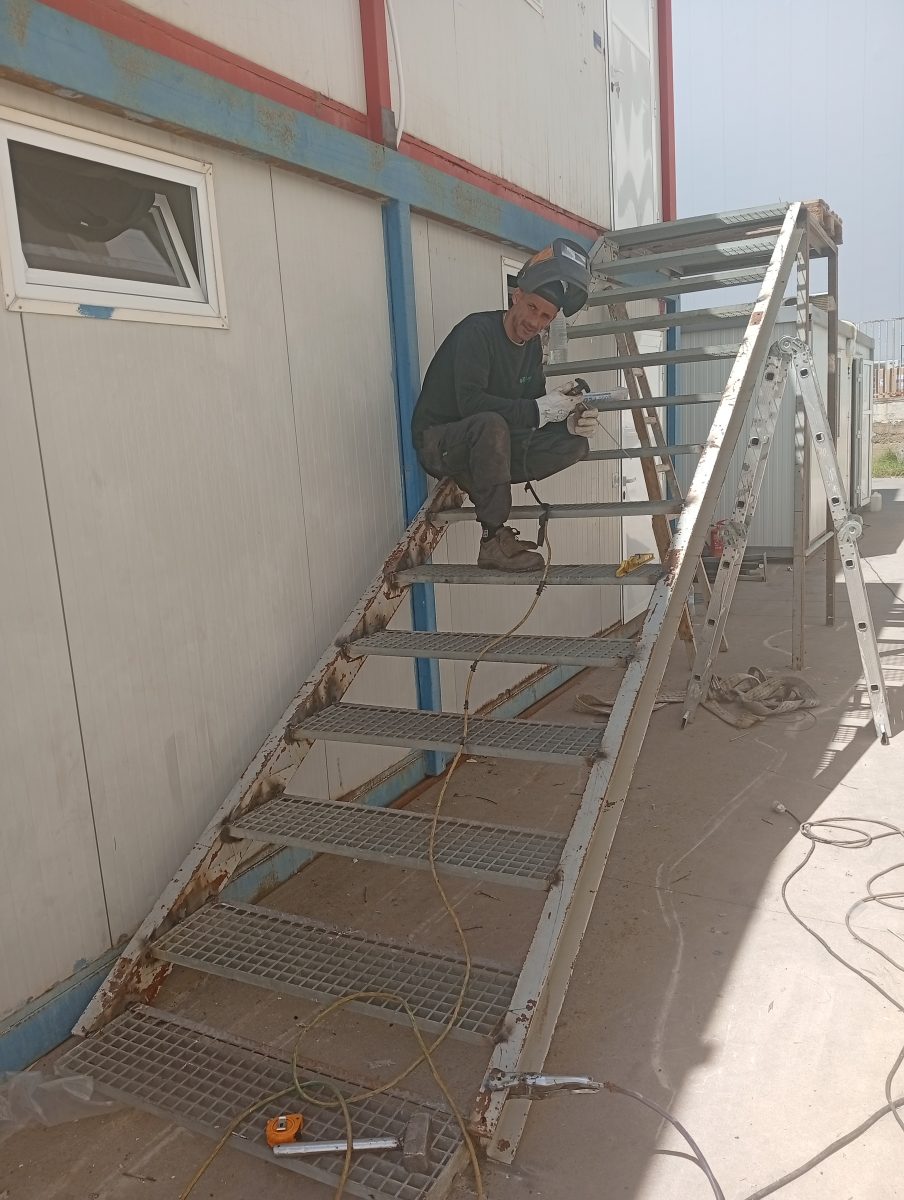 Soudeur sur un escalier métallique à marches caillebotis, en fabrication