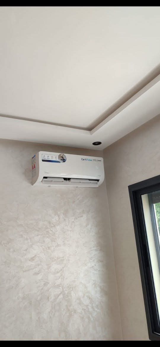 Climatiseur mural installé en angle sous un faux plafond