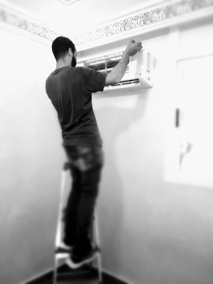 Technicien installant une unité de climatisation murale