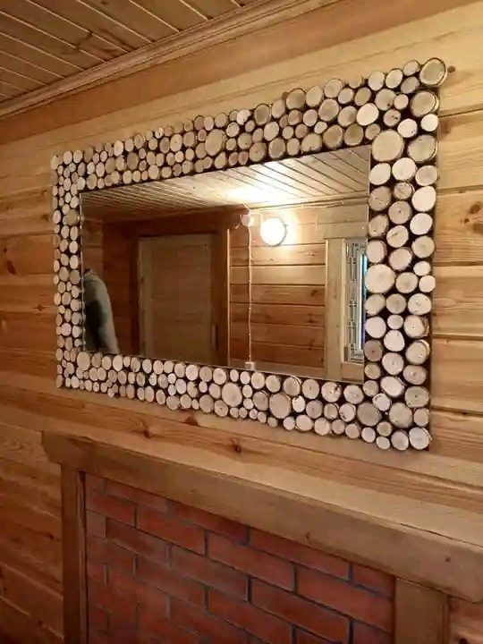 Miroir mural encadré de rondelles de bois au-dessus d'une cheminée