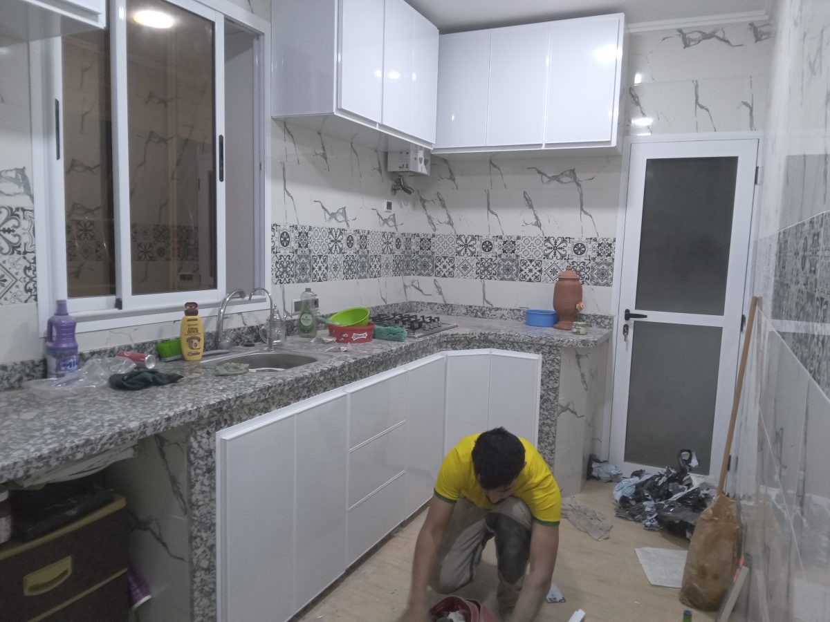 Cuisine en L blanche à plan en granit et crédence carrelée