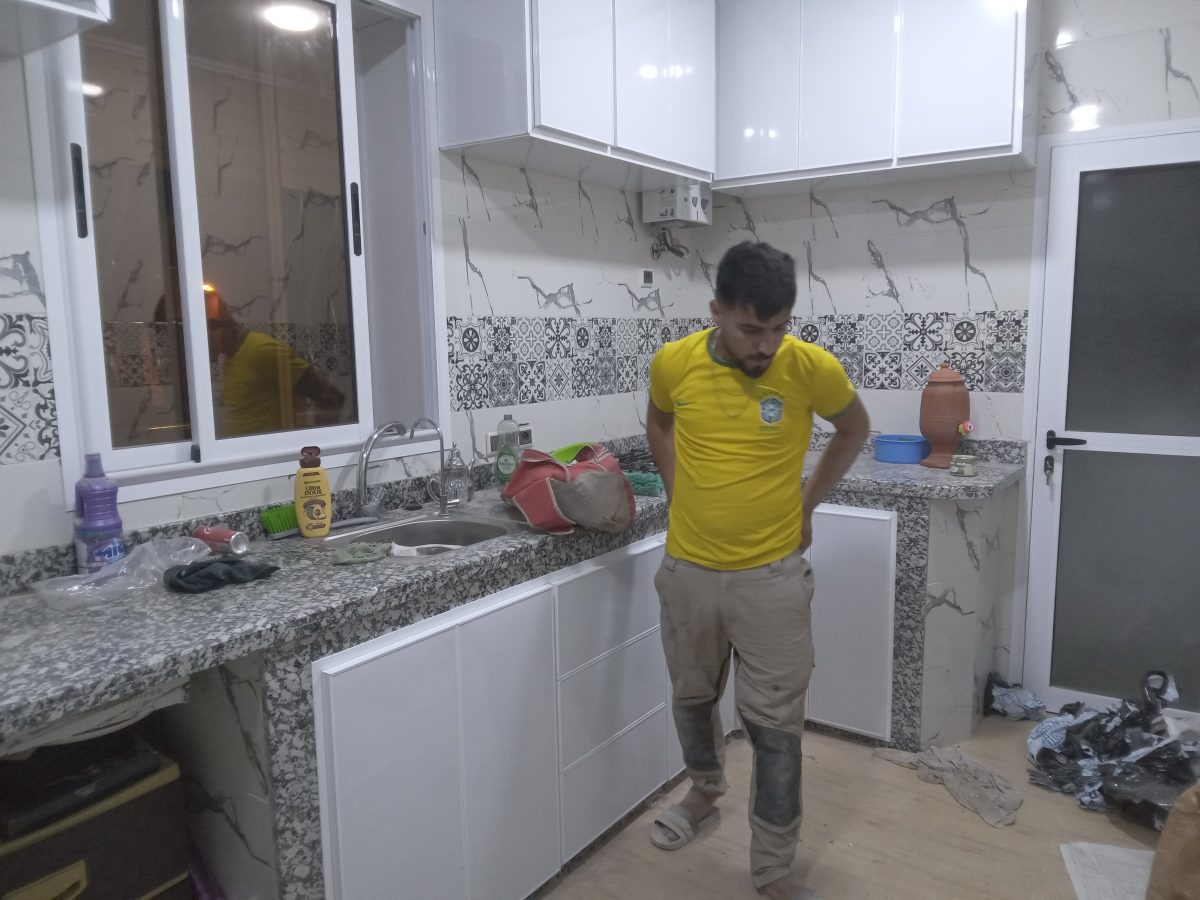 Cuisine en L blanche laque a plan granit moucheté, en cours