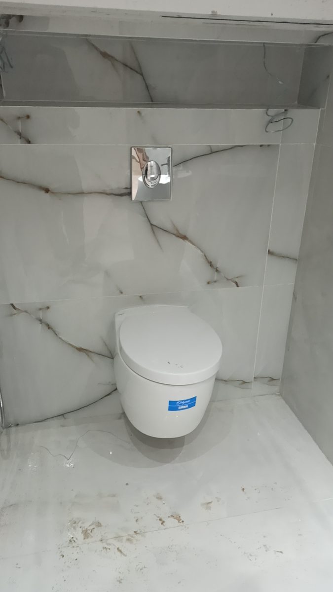 WC suspendu blanc dans une niche effet marbre veiné d'or
