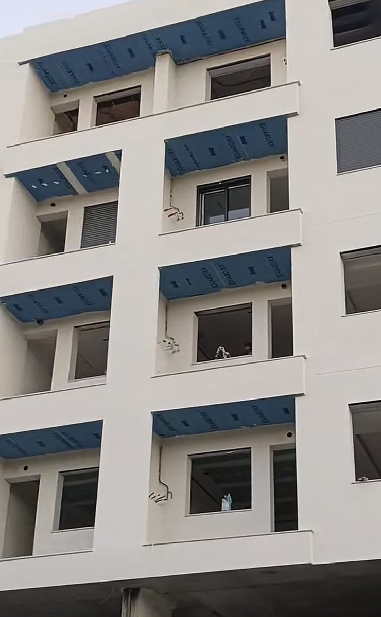 Immeuble à façade enduite blanc casse, en cours