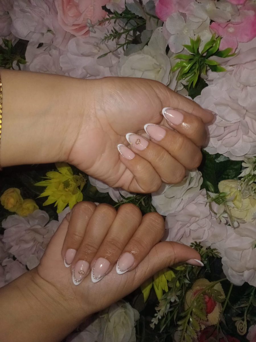 Ongles en French manucure amande avec cœurs sur un mur de fleurs