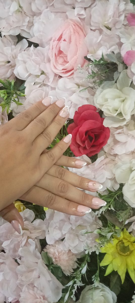 Ongles en French manucure sur un mur de fleurs