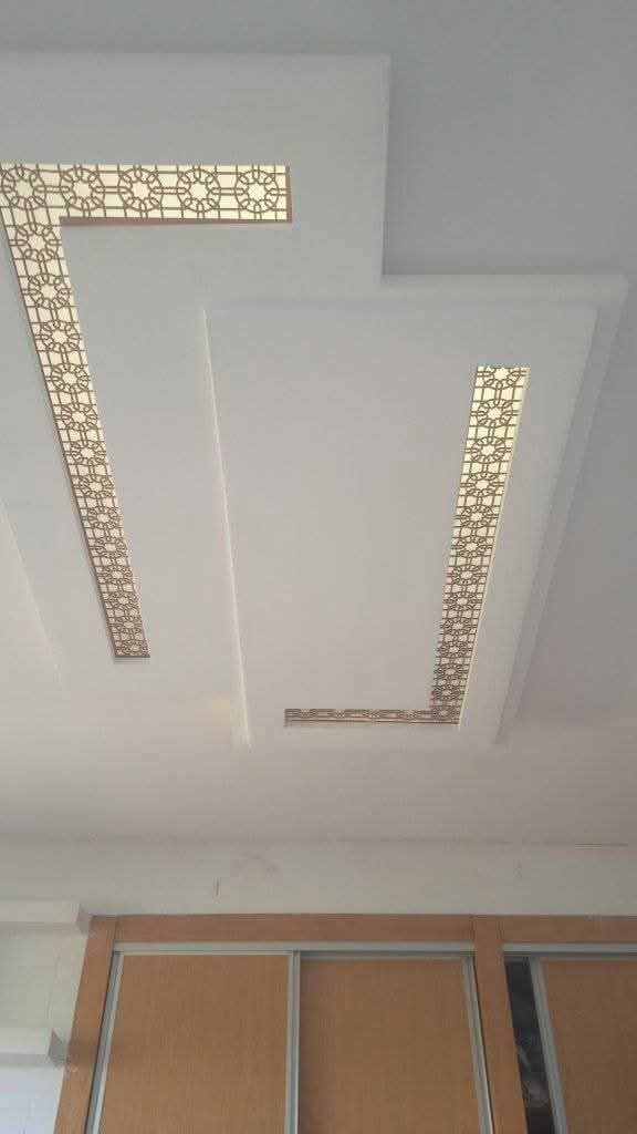 Faux plafond blanc à bandes moucharabieh dorées rétroéclairées
