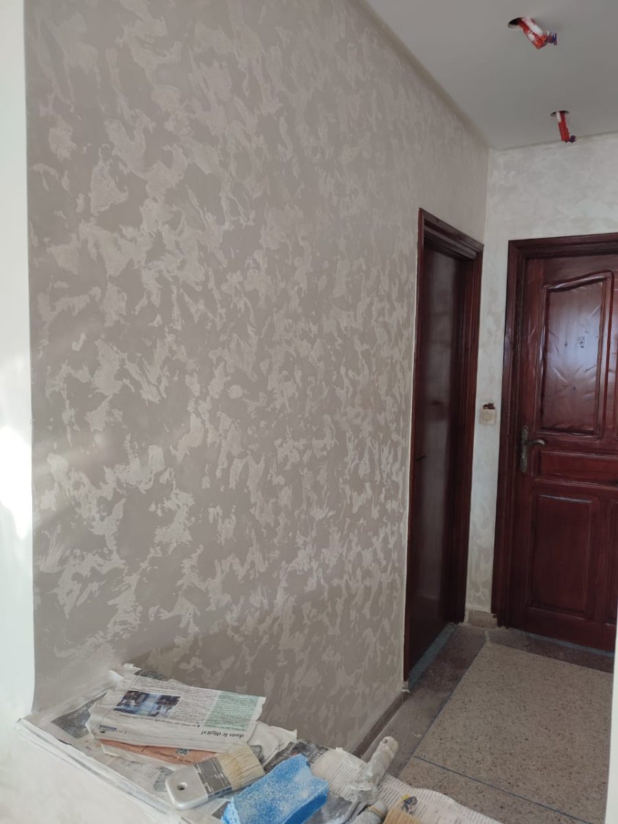Mur en peinture décorative nacrée effet éponge gris-beige, en cours