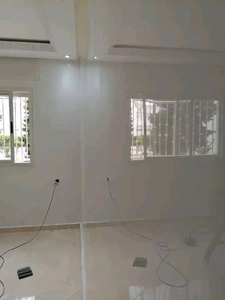 Séjour aux murs blanc brillant et faux plafond à décrochés