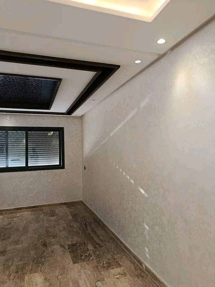 Chambre à enduit nacré beige et faux plafond à claustra noir