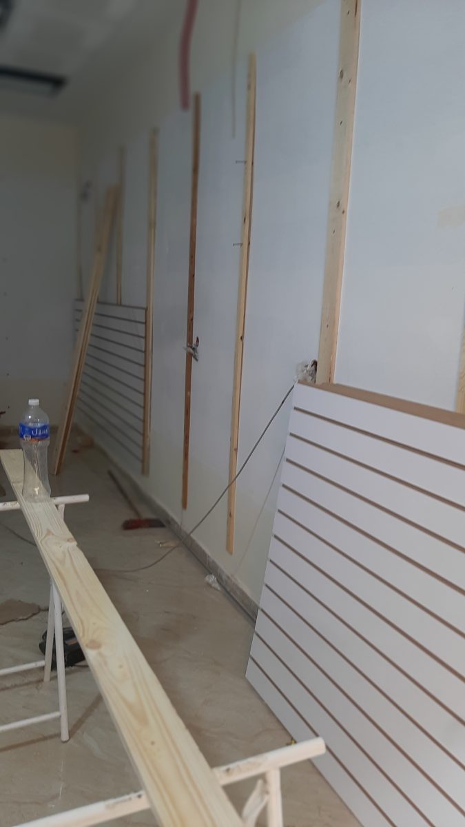 Habillage mural en lattes blanches en cours de pose