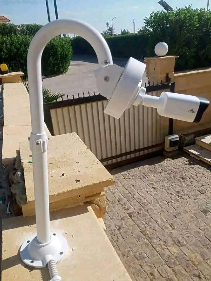 Deux caméras de surveillance sur un mat devant un portail
