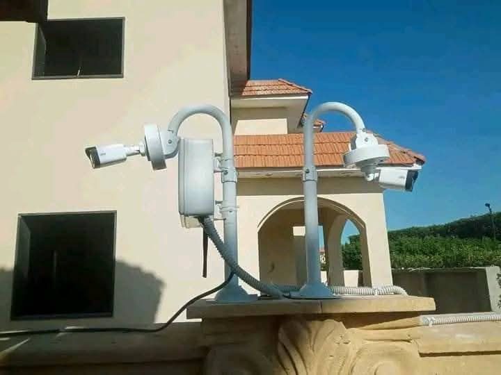 Ensemble de caméras fixées sur un pilier devant une villa