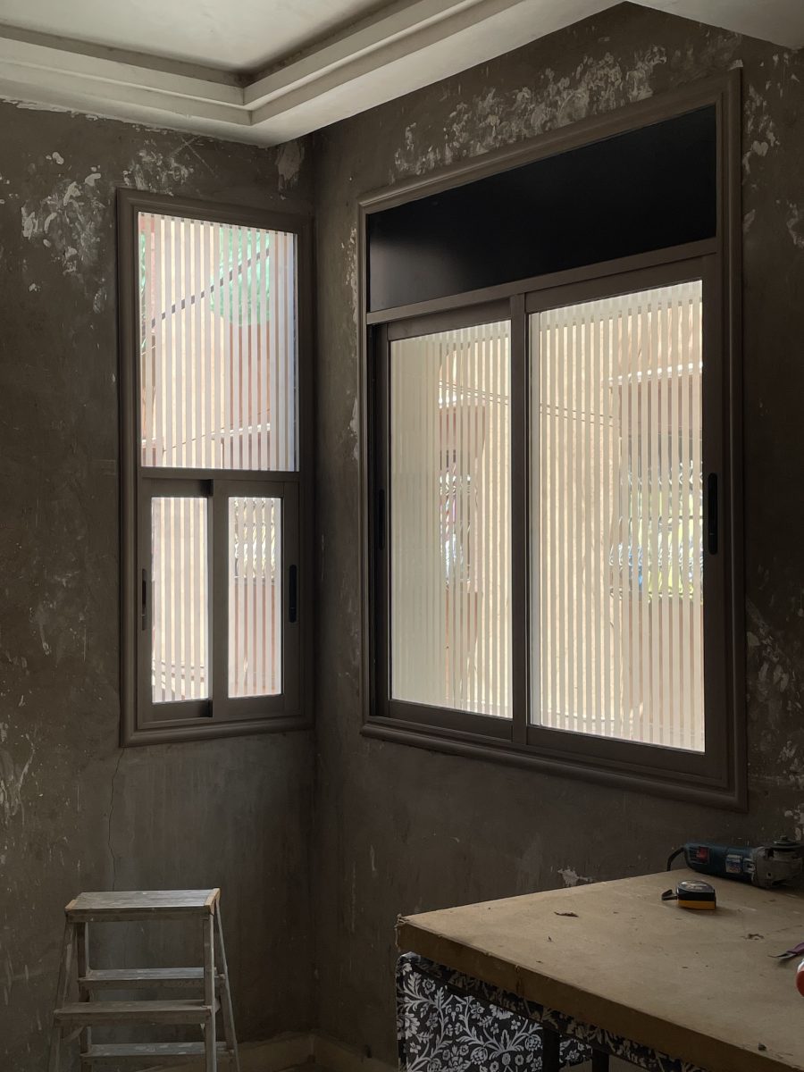 Fenêtres coulissantes en aluminium taupe avec volet roulant, en cours