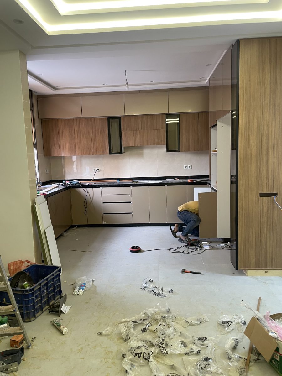 Cuisine en L à façades bois et taupe avec plan granit, en cours