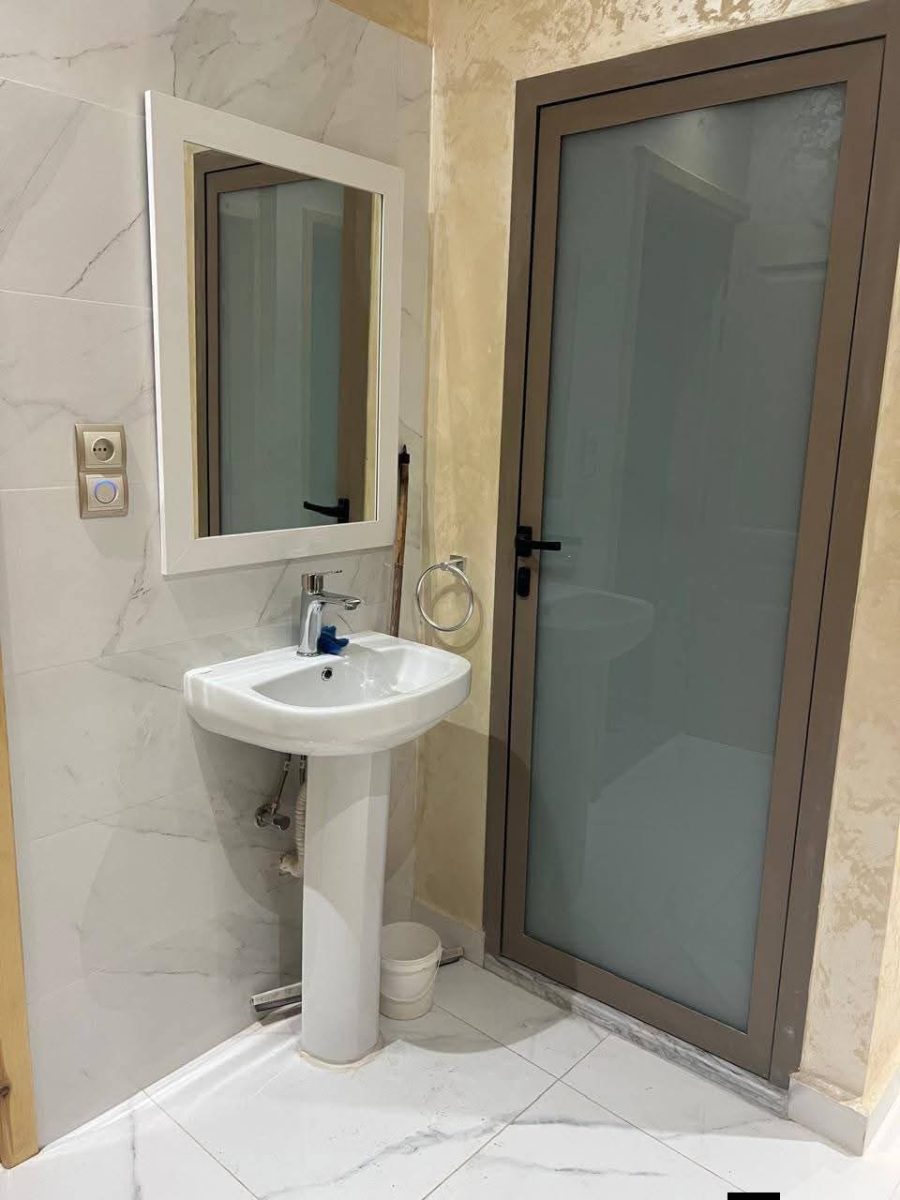 Salle d'eau avec porte en aluminium taupe à vitrage dépoli