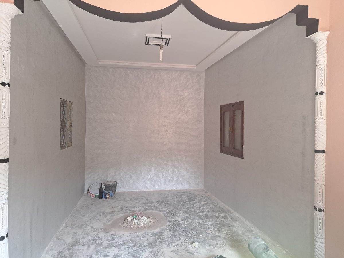 Salle à plafond à corniche courbe et murs en enduit nacré gris