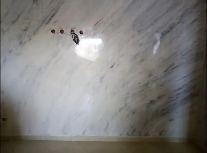 Mur en grandes dalles effet marbre blanc veiné, en cours