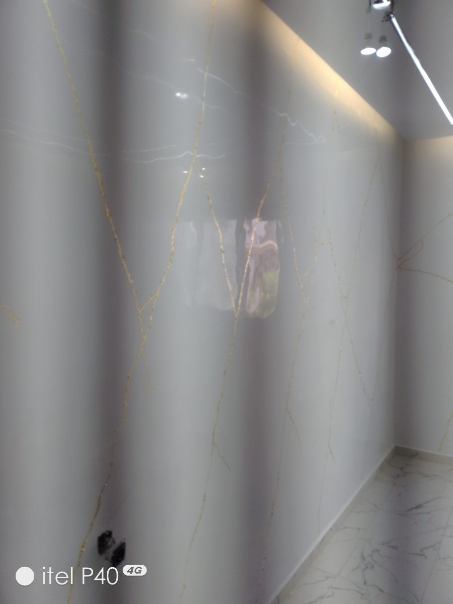Mur en grandes dalles effet marbre beige veiné d'or