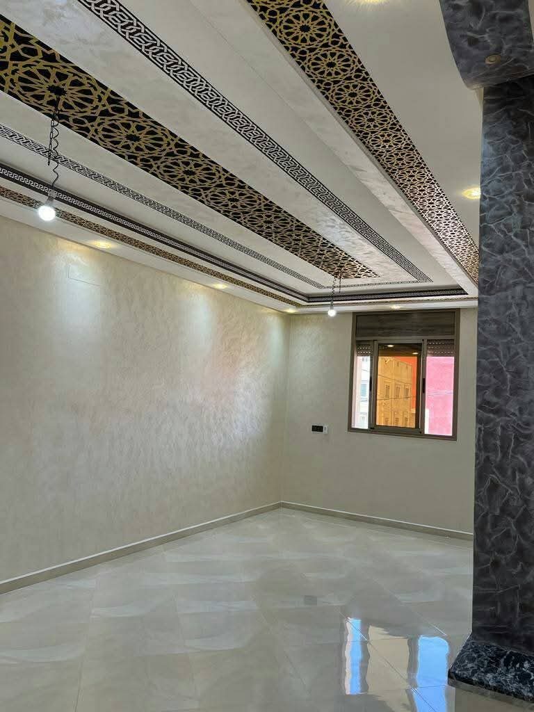Salon à faux plafond arabesque noir et or et murs en enduit nacré