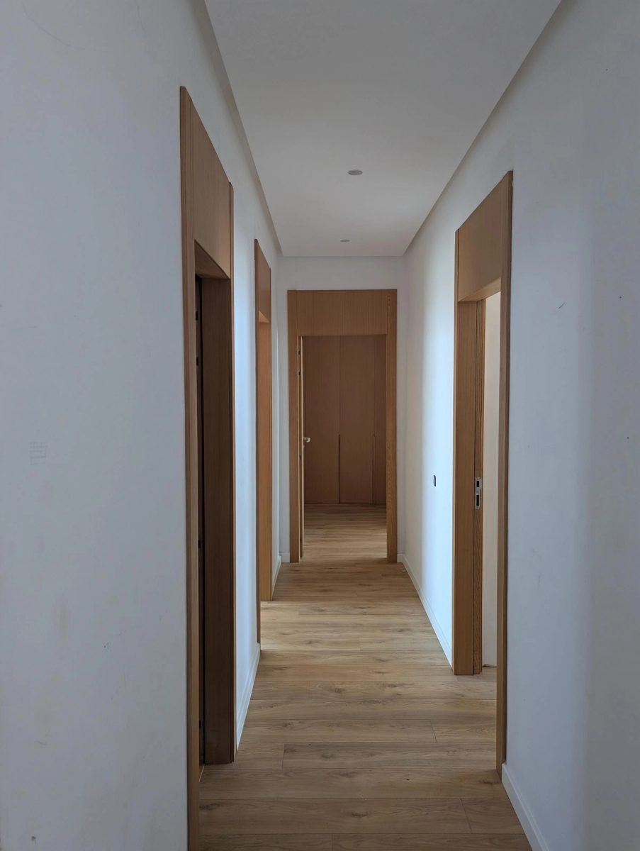 Couloir à portes en bois et parquet stratifié