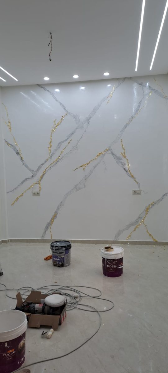 Séjour à mur effet marbre veiné d'or et LED, en cours