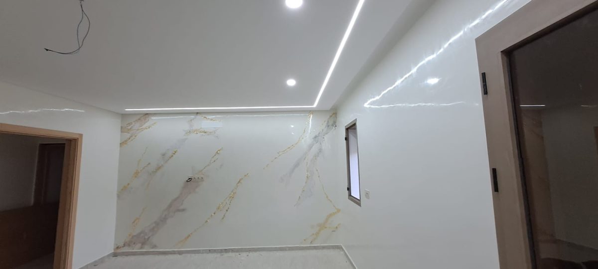 Séjour à mur effet marbre blanc veiné d'or et LED