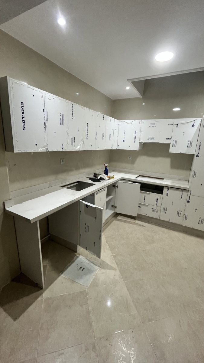 Cuisine en U à façades blanches et plan effet marbre, en cours
