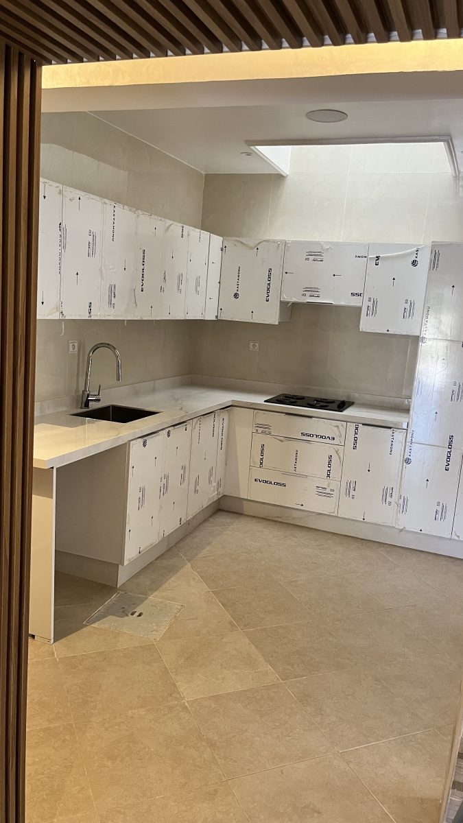 Cuisine en U à façades blanches et plan effet marbre, en cours