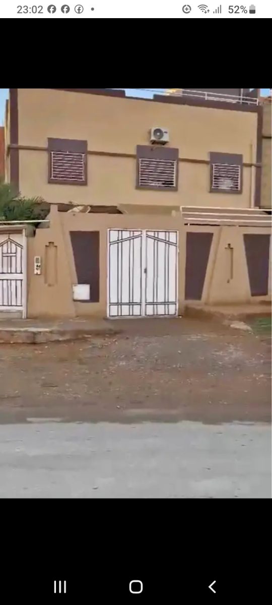 Façade d'une maison à vendre avec portail blanc