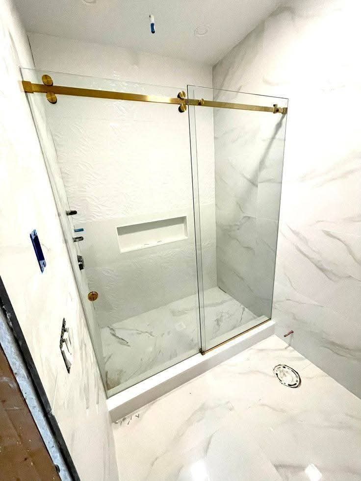 Cabine de douche à parois vitrées coulissantes et rail doré