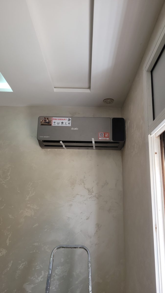 Climatiseur mural gris installé sous un faux plafond