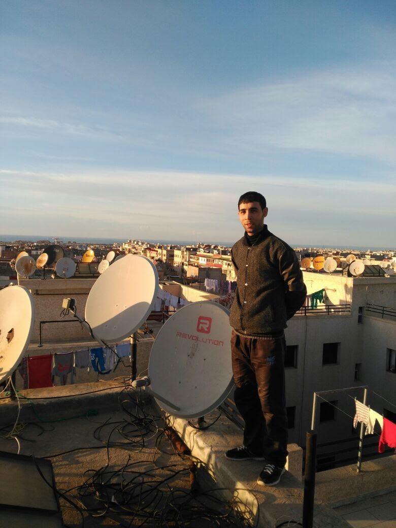 Technicien sur une terrasse couverte de paraboles au crépuscule