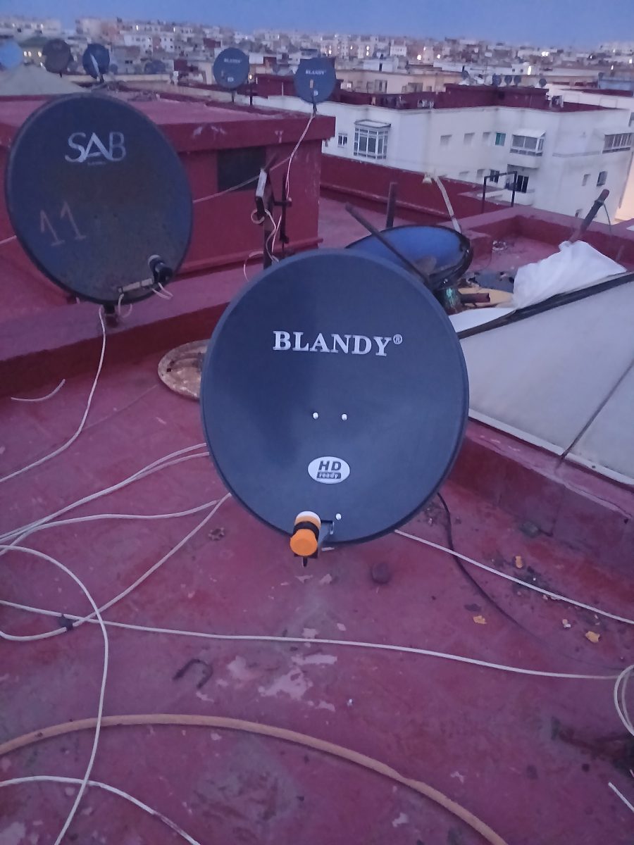 Plusieurs paraboles satellite sur une terrasse, au crepuscule