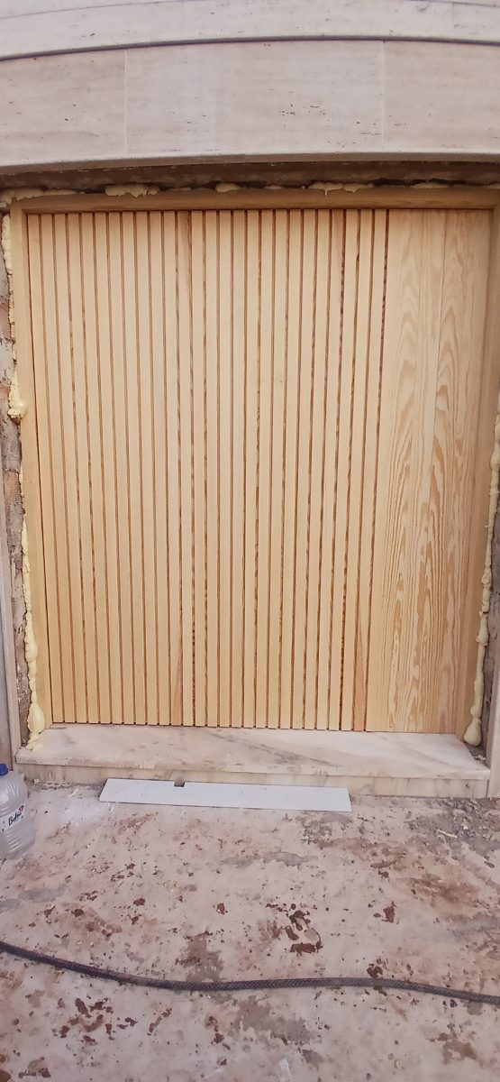 Renfoncement habillé de tasseaux de bois clair encadré de marbre