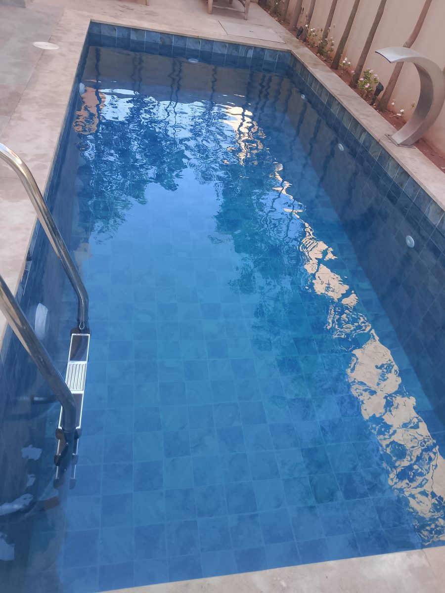 Piscine en zellige bleu avec escalier inox et lame d'eau