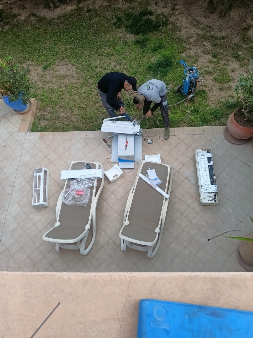 Techniciens préparant des unités de climatisation dans un jardin