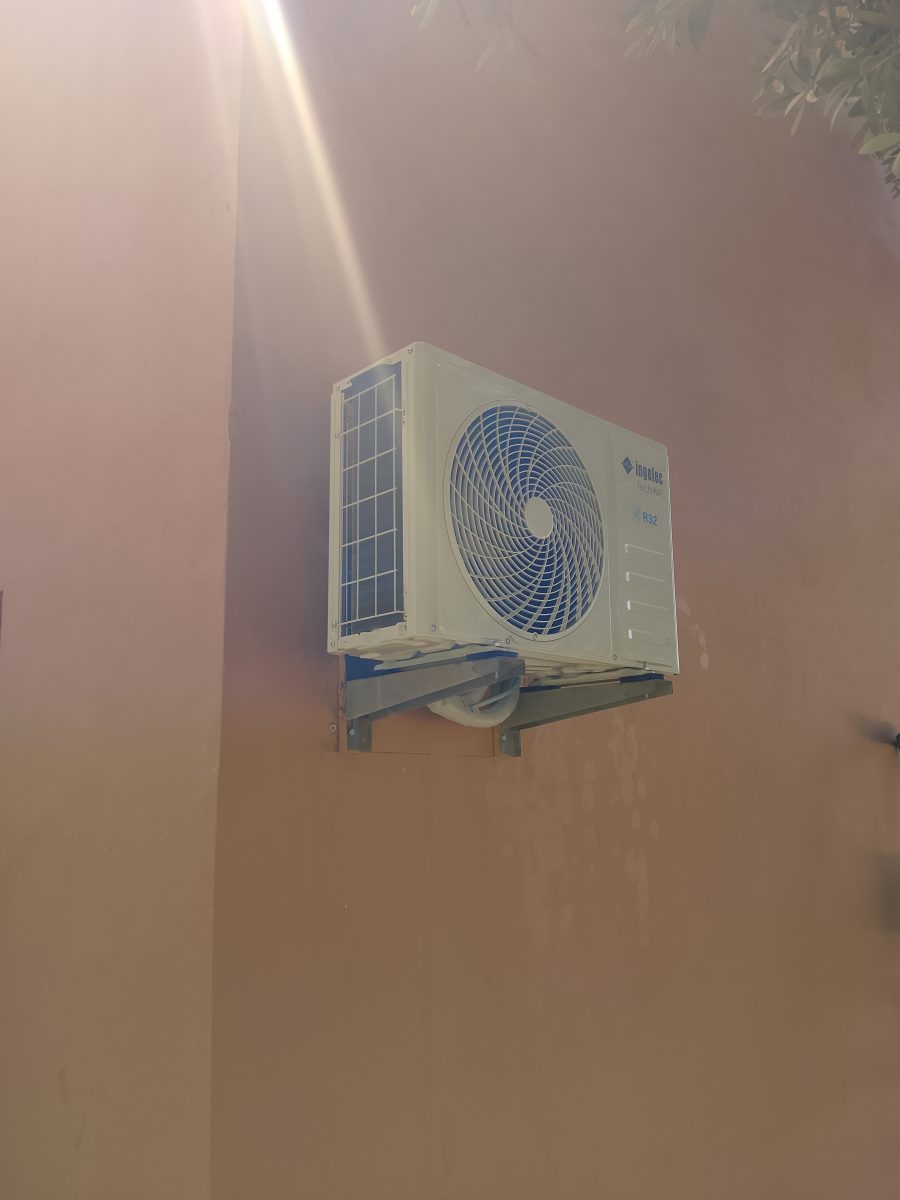 Techniciens préparant des unités de climatisation dans un jardin