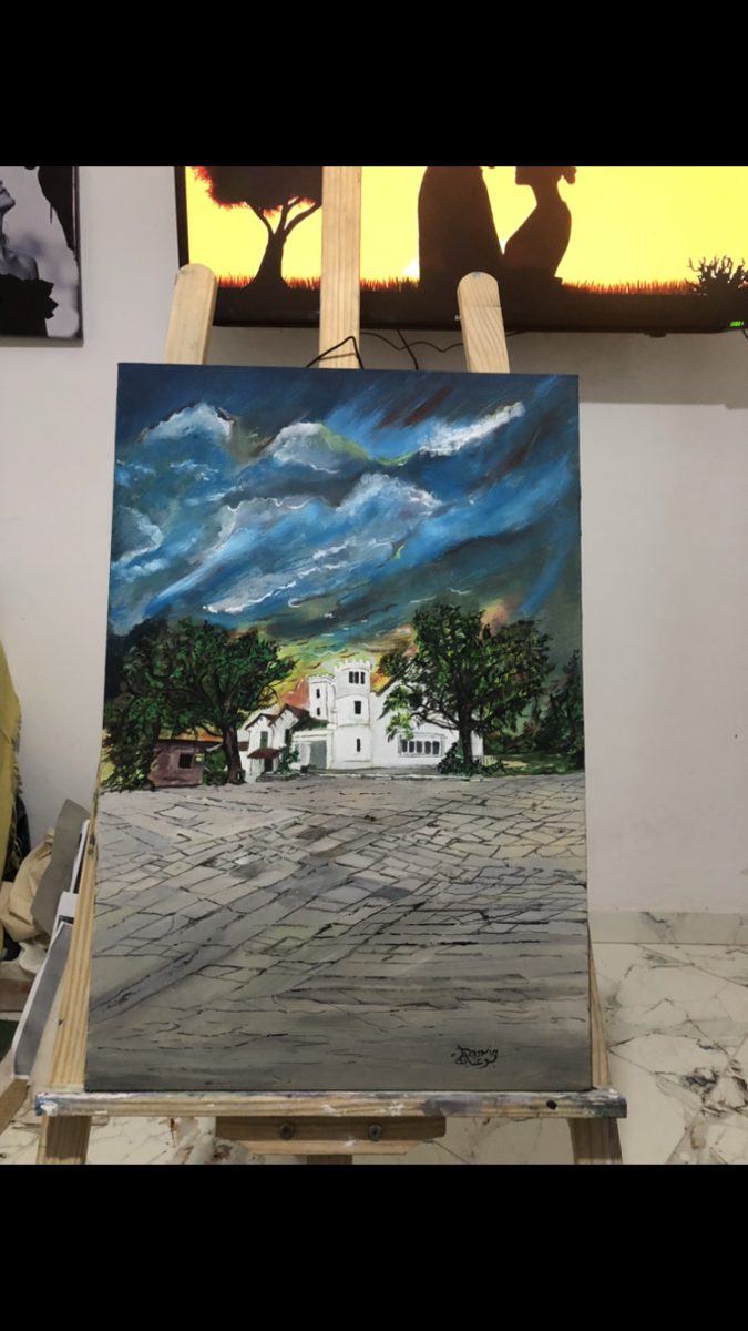 Tableau d'un village blanc sous ciel orageux sur un chevalet