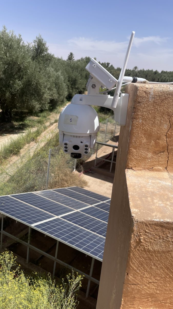 Caméra PTZ solaire installée sur un muret dans une palmeraie