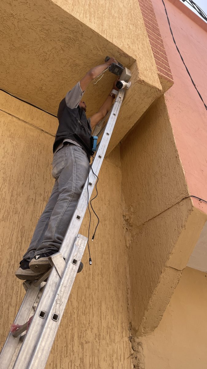 Installation d'une caméra en haut d'une façade depuis une échelle