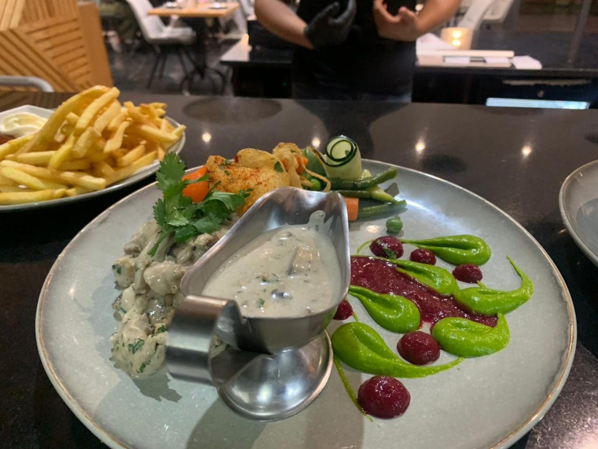 Assiette dressée en sauce crémée avec légumes et saucière
