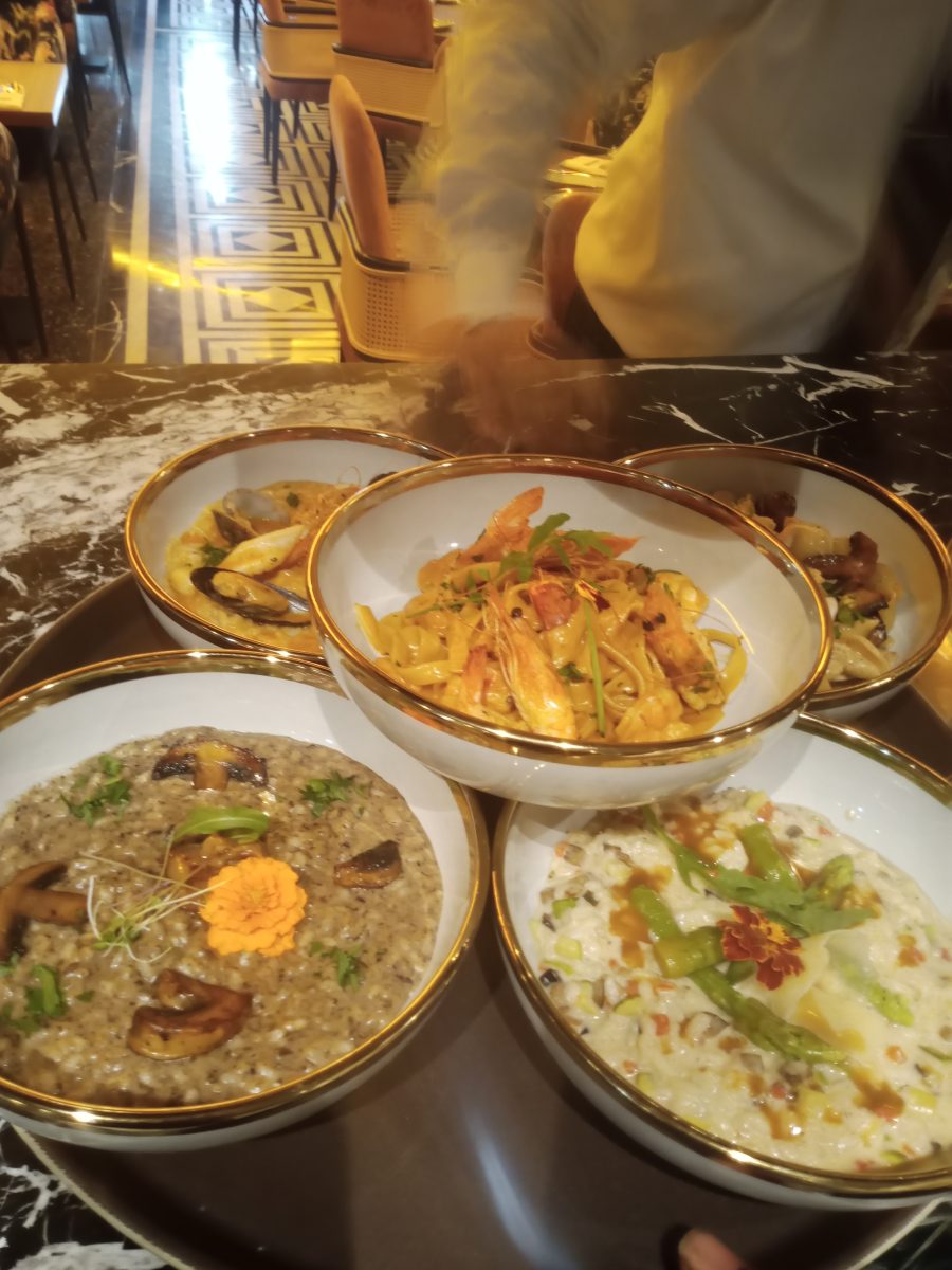 Trois assiettes gastronomiques dressées sur un plateau doré
