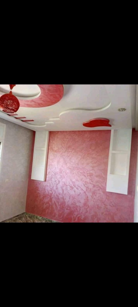 Chambre à faux plafond design rouge et blanc et murs en enduit rose