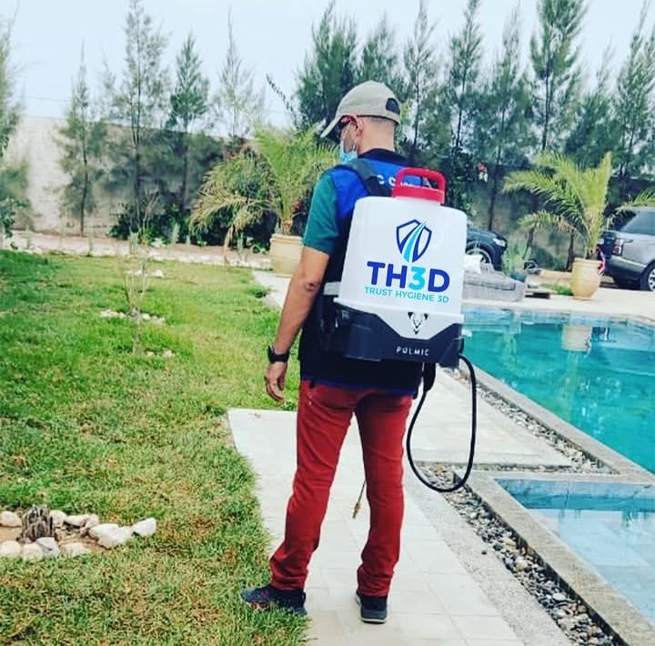 Agent avec pulvérisateur dorsal au bord d'une piscine