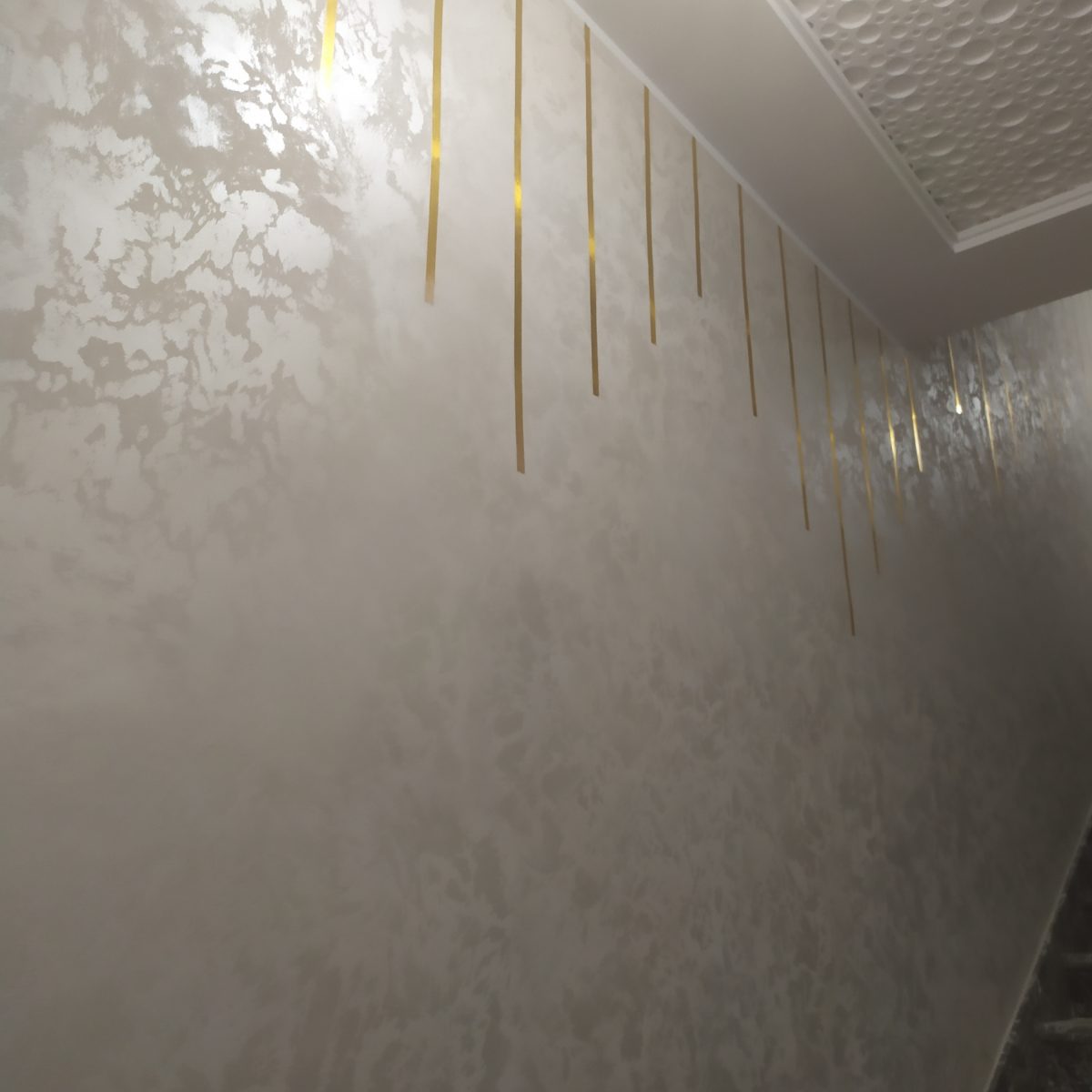 Mur en enduit décoratif nacré argenté à filets dorés