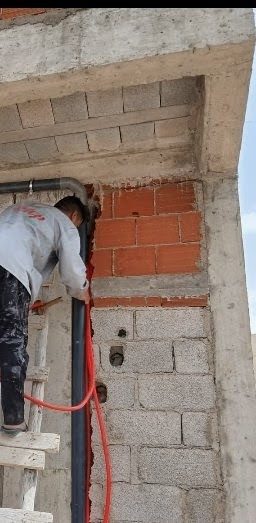 Passage d'une canalisation à travers un mur en briques sur chantier