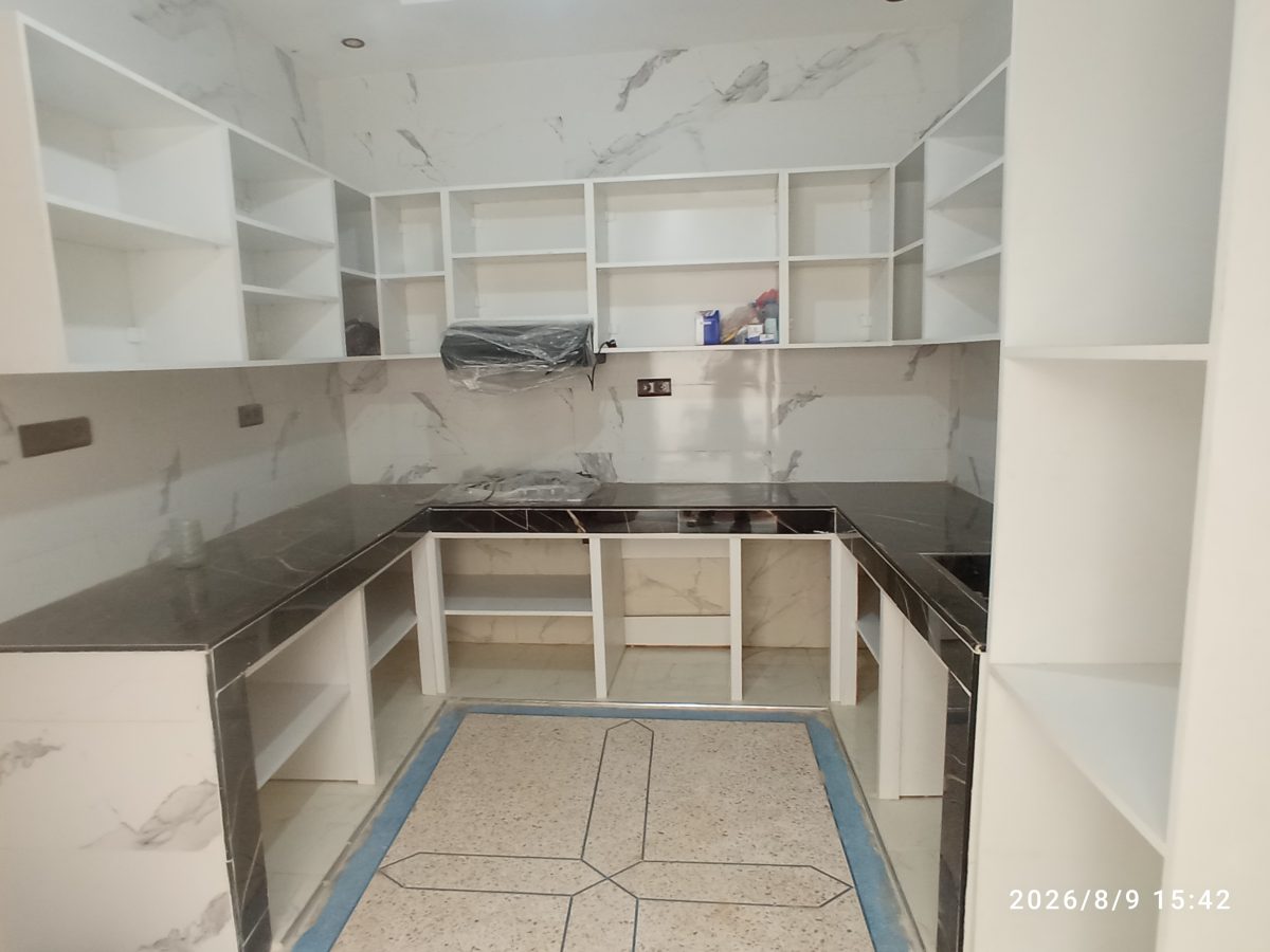 Cuisine en U à caissons blancs et plan effet marbre noir, en cours